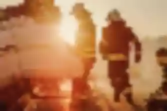 Emergency responders working overturned car crash scene at sunset, serious accident requiring a personal injury lawyer