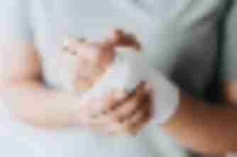 Woman cradling her gauze-wrapped wrist, a common injury in personal injury claims