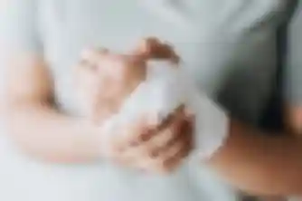 Woman cradling her gauze-wrapped wrist, a common injury in personal injury claims