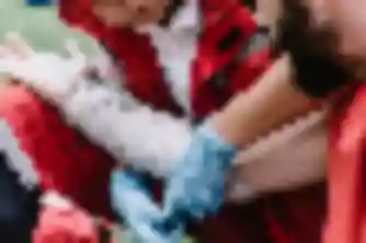 Paramedic in gloves examining injured man