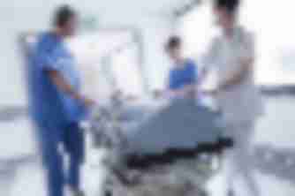Medical staff rushing patient on gurney through hospital hallway, emergency care relevant to personal injury cases