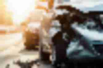 Silver car with crushed front end wreckage on roadside street, damage typical of a personal injury car accident case
