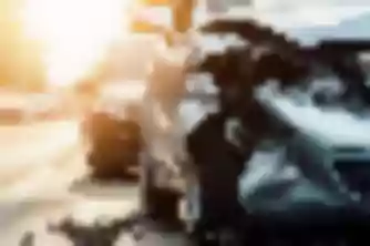 Silver car with crushed front end wreckage on roadside street, damage typical of a personal injury car accident case